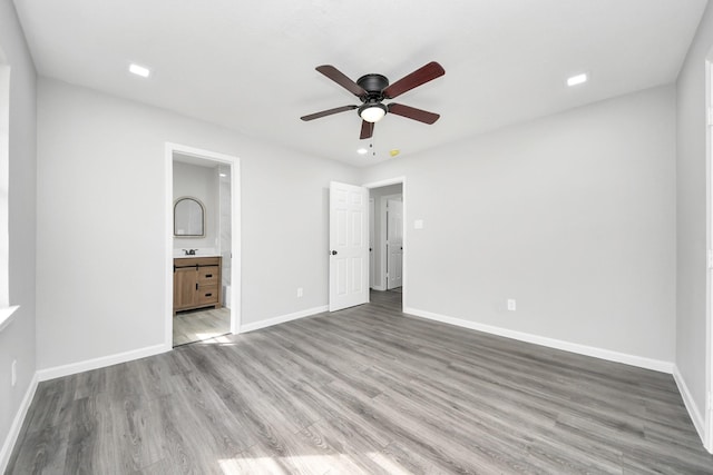 unfurnished bedroom with baseboards, connected bathroom, light wood finished floors, and ceiling fan