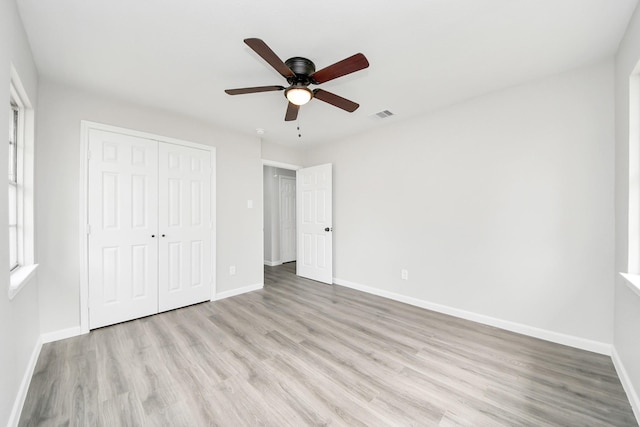 unfurnished bedroom with light wood-style flooring, visible vents, and baseboards