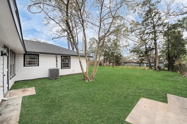 view of yard featuring central AC and fence