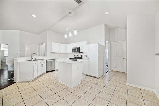 kitchen with a peninsula, stainless steel appliances, pendant lighting, and light countertops