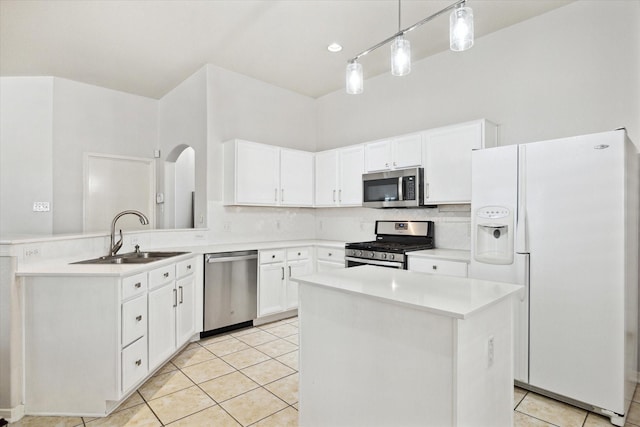 kitchen with a center island, stainless steel appliances, light countertops, white cabinets, and a sink