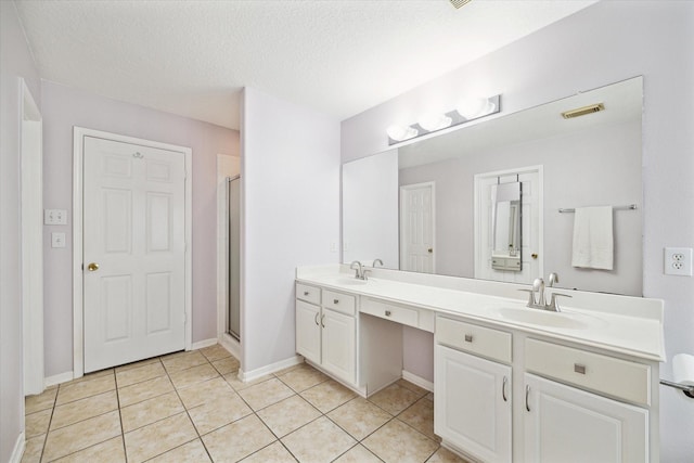 bathroom with double vanity, a stall shower, tile patterned flooring, and a sink