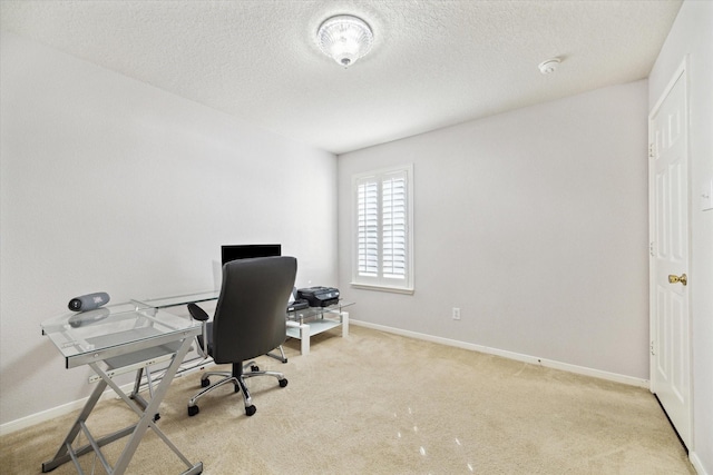 office space with baseboards, a textured ceiling, and light colored carpet