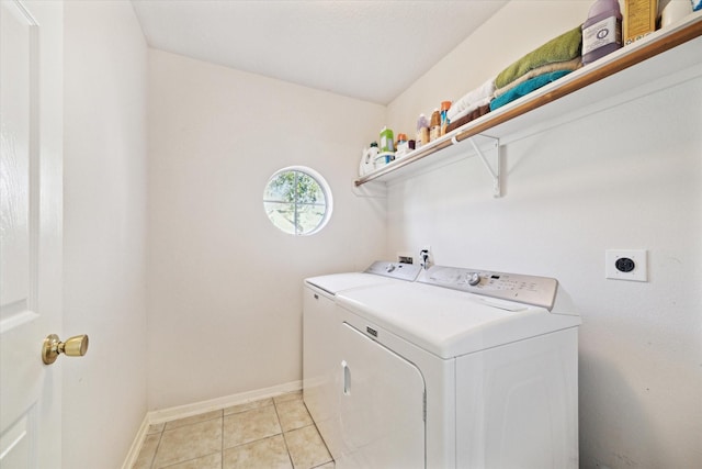 laundry area featuring light tile patterned floors, laundry area, baseboards, and washer and dryer