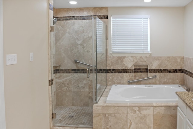 bathroom featuring a stall shower, a bath, and recessed lighting