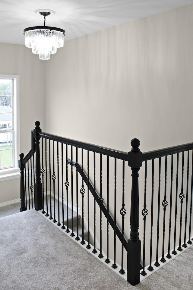 stairs featuring carpet, a notable chandelier, and baseboards