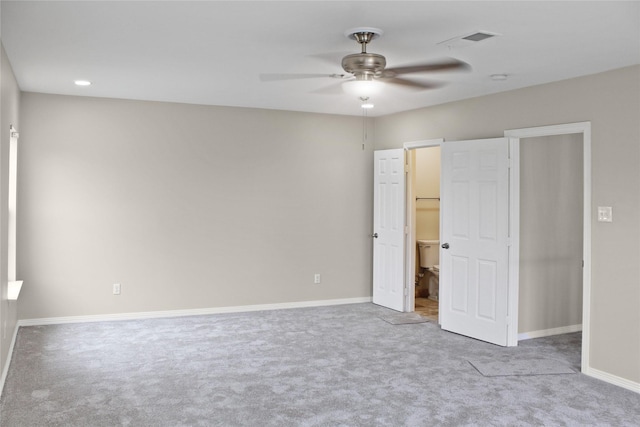 unfurnished bedroom featuring carpet floors, visible vents, a spacious closet, a ceiling fan, and baseboards