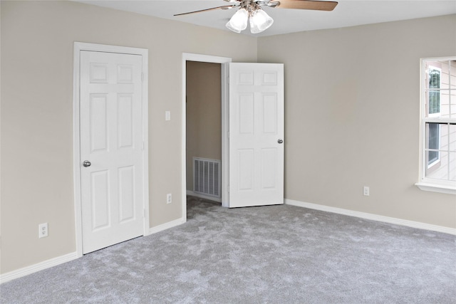 unfurnished bedroom with carpet floors, visible vents, baseboards, and a ceiling fan