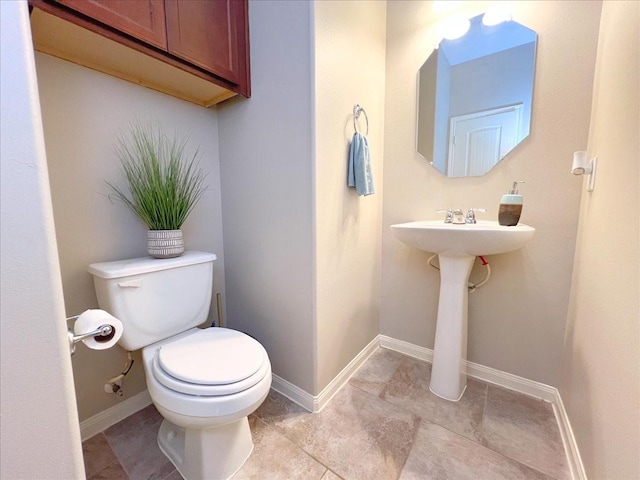 bathroom featuring toilet and baseboards