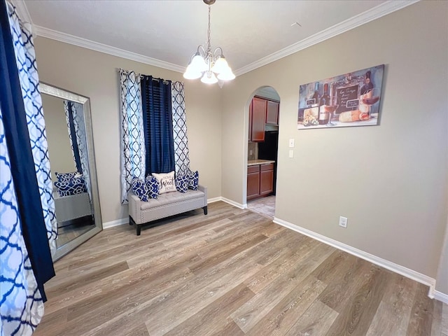 unfurnished room with arched walkways, baseboards, light wood-style flooring, ornamental molding, and an inviting chandelier