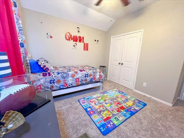 carpeted bedroom with lofted ceiling, a closet, a ceiling fan, and baseboards