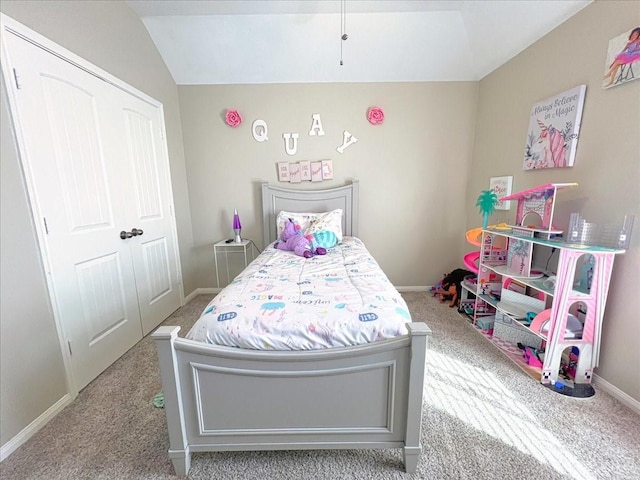 bedroom with lofted ceiling, a closet, light carpet, and baseboards