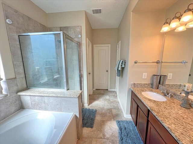 bathroom with visible vents, baseboards, a garden tub, vanity, and a shower stall