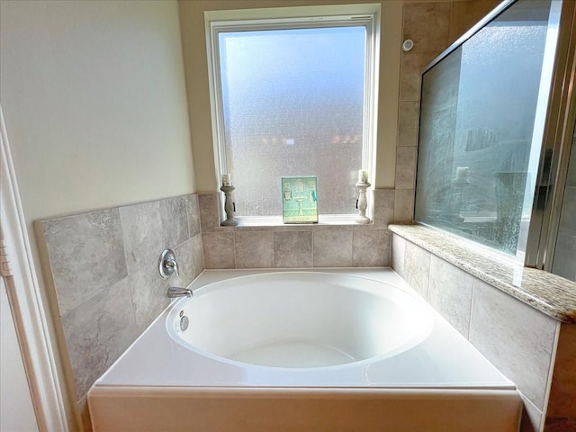 bathroom with a garden tub and a shower with shower door