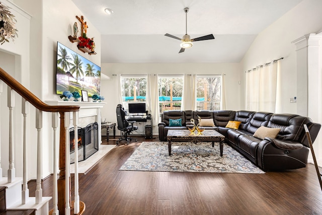 living room with a ceiling fan, lofted ceiling, a premium fireplace, dark wood-type flooring, and stairs