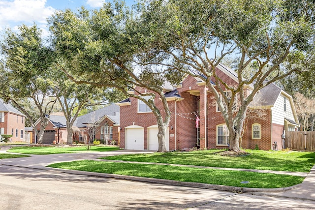 view of front of home featuring fence, a front lawn, concrete driveway, and brick siding