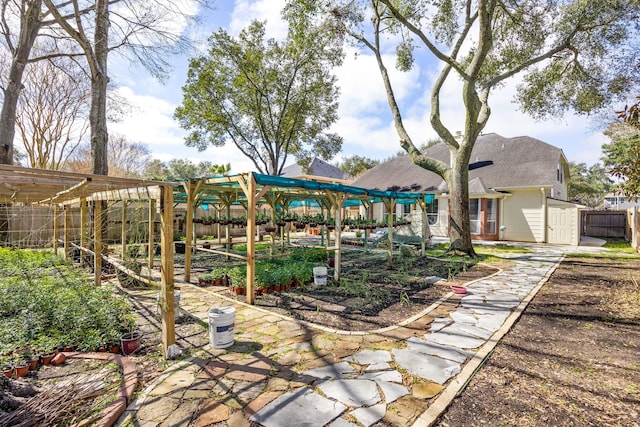 view of yard featuring an outbuilding, a shed, fence, and a pergola