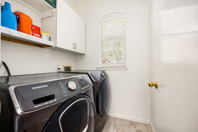 laundry room featuring baseboards, cabinet space, and washing machine and clothes dryer