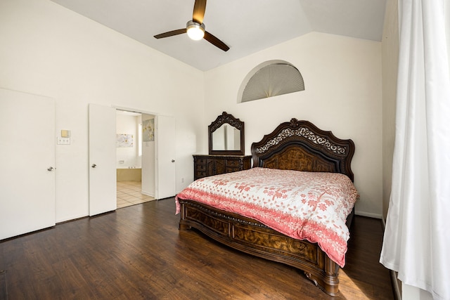 bedroom featuring a ceiling fan, vaulted ceiling, ensuite bath, and wood finished floors