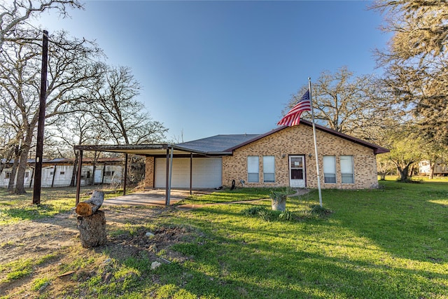 view of front facade featuring driveway, a garage, a front yard, a carport, and brick siding