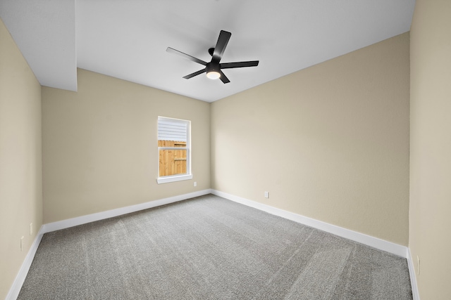 carpeted empty room featuring ceiling fan and baseboards