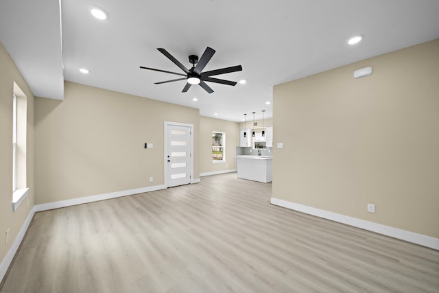 unfurnished living room with light wood finished floors, baseboards, a ceiling fan, and recessed lighting