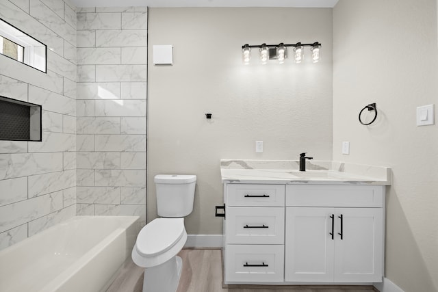 full bath featuring toilet, vanity, shower / tub combination, wood finished floors, and baseboards