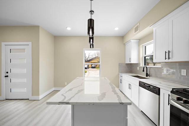 kitchen featuring visible vents, white cabinets, a kitchen island, decorative light fixtures, and stainless steel appliances