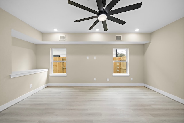 empty room featuring baseboards, visible vents, and light wood finished floors