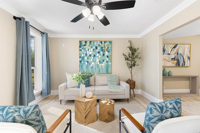 living area featuring light wood-style floors, baseboards, ornamental molding, and ceiling fan