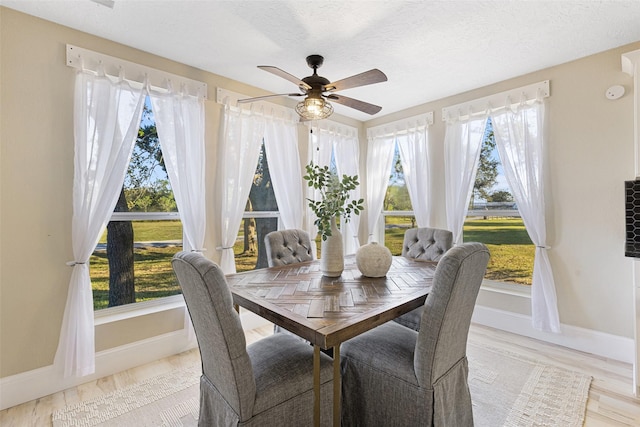 dining area with a textured ceiling, ceiling fan, and baseboards