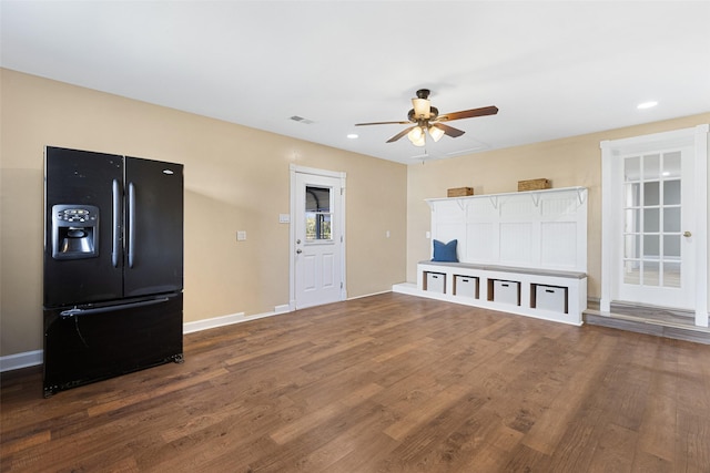 unfurnished living room with dark wood-style floors, ceiling fan, visible vents, and baseboards