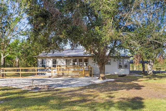 view of front facade with a front lawn and a wooden deck