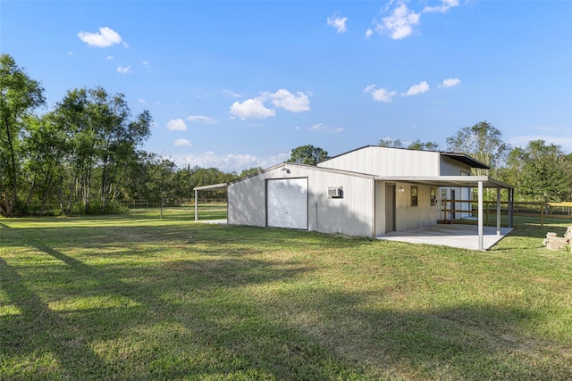 exterior space featuring driveway, a lawn, a detached garage, and fence