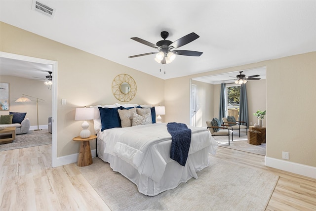 bedroom featuring baseboards, ceiling fan, visible vents, and light wood-style floors