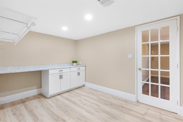 interior space featuring light wood-style floors, visible vents, and baseboards