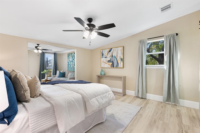 bedroom with ceiling fan, visible vents, baseboards, vaulted ceiling, and light wood-type flooring