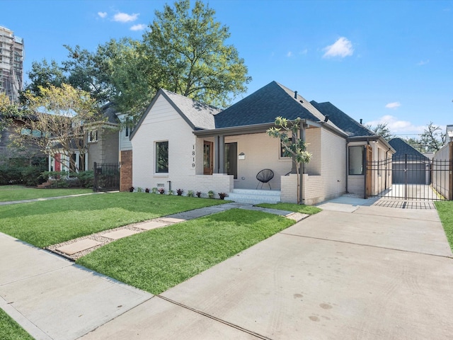 view of front facade featuring brick siding, a shingled roof, a front yard, a gate, and fence