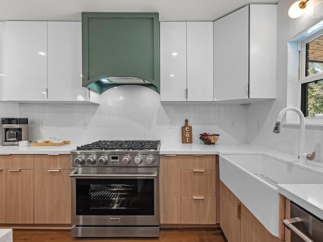 kitchen with custom range hood, stainless steel appliances, modern cabinets, and white cabinets