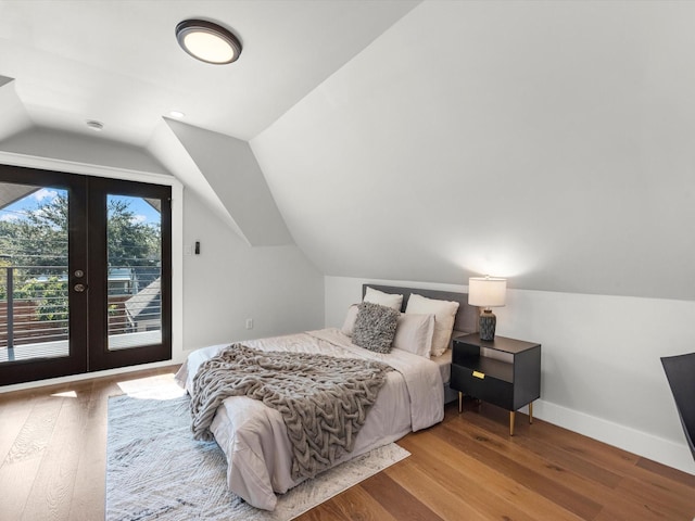 bedroom with french doors, lofted ceiling, wood finished floors, access to outside, and baseboards