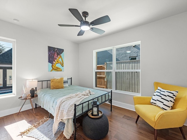 bedroom with ceiling fan, baseboards, and wood finished floors