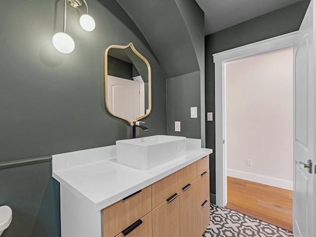 bathroom with wood finished floors, vanity, and baseboards