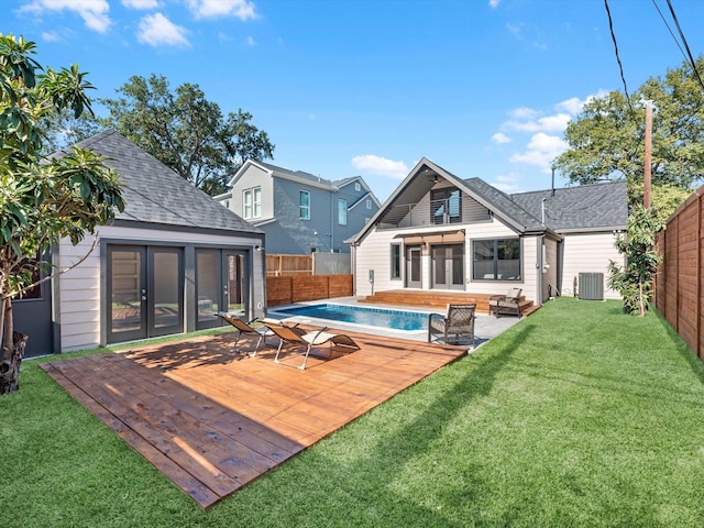 rear view of house featuring a fenced backyard, central AC, a sunroom, a wooden deck, and a fenced in pool