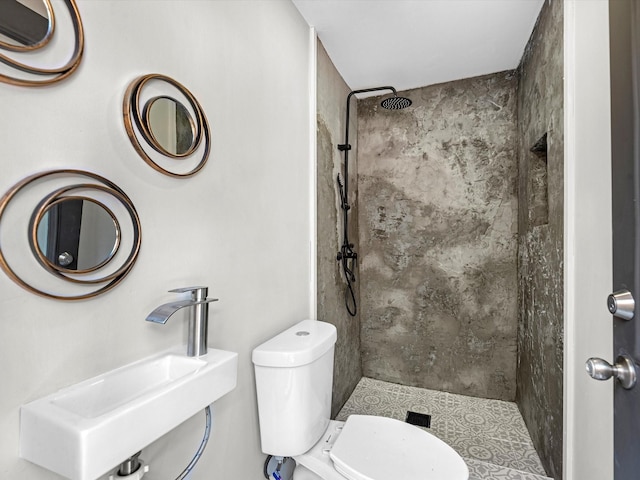 bathroom with toilet, a shower stall, and a sink