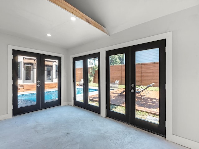 doorway featuring concrete flooring, recessed lighting, french doors, and beamed ceiling