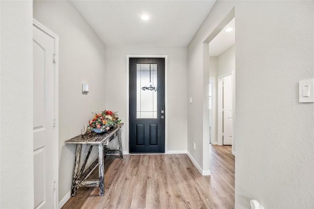 foyer featuring baseboards and light wood-style floors