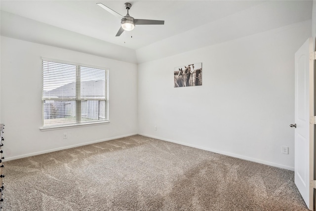 carpeted empty room featuring a ceiling fan, lofted ceiling, and baseboards