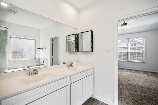 bathroom with baseboards, a sink, a bath, and double vanity