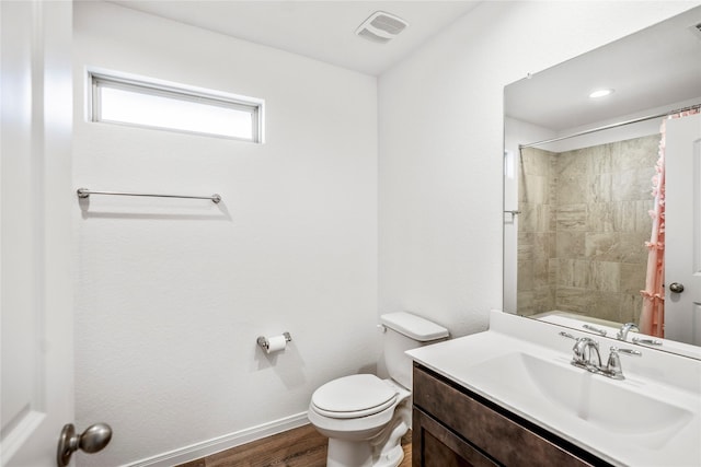 full bathroom with baseboards, visible vents, toilet, wood finished floors, and vanity