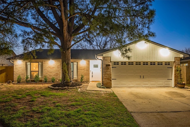 view of front of house with a front lawn, driveway, an attached garage, and fence